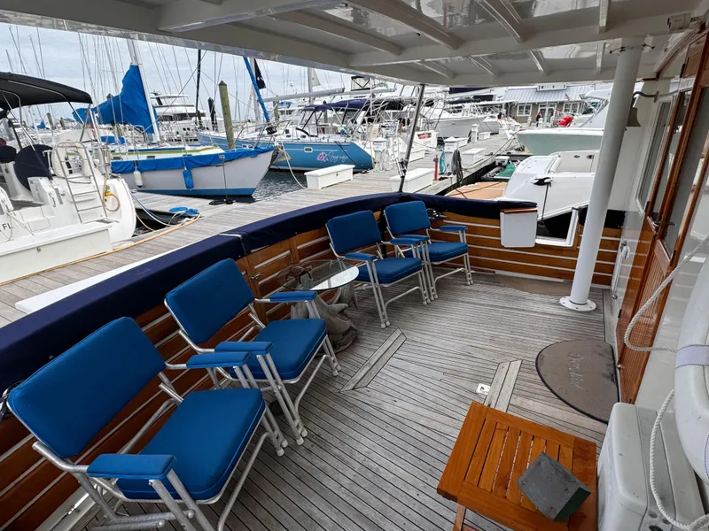 Slide: The Image of Deck of 1996 Kadey-Krogen 48 yacht with blue chairs and marina view. - 15