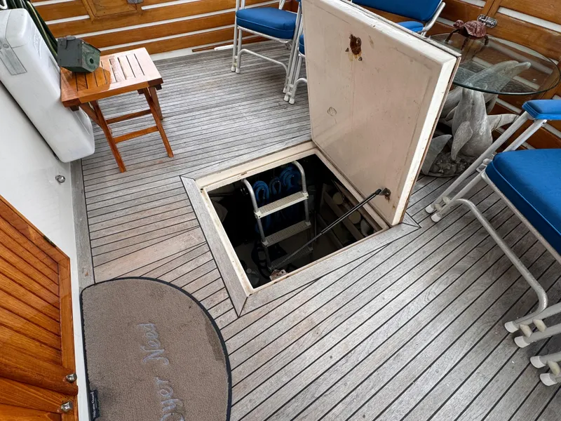 Slide: The Image of Open hatch on 1996 Kadey-Krogen 48 yacht deck with blue chairs and table. - 16