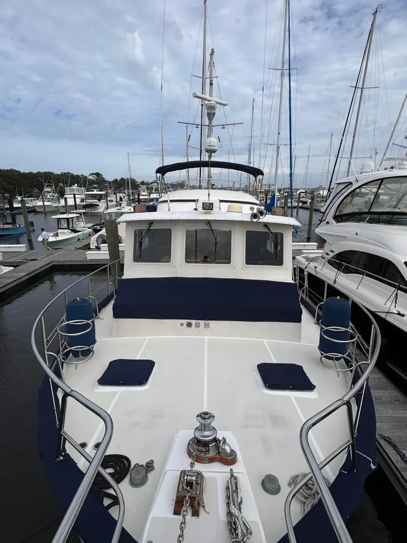 Slide: The Image of Kadey-Krogen 48 yacht from 1996 docked at a marina, surrounded by other boats. - 20