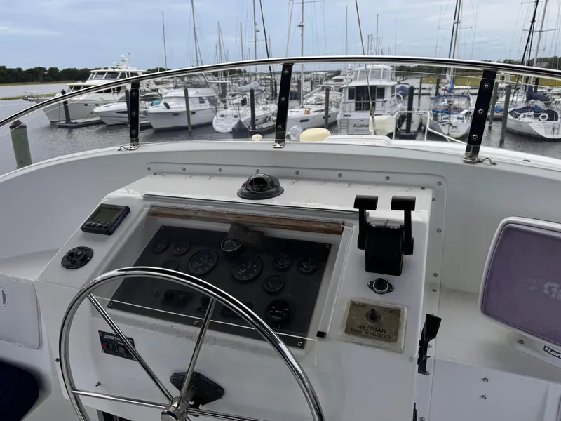 Slide: The Image of Helm of 1996 Kadey-Krogen 48 yacht with steering wheel and control panel, docked at marina. - 26