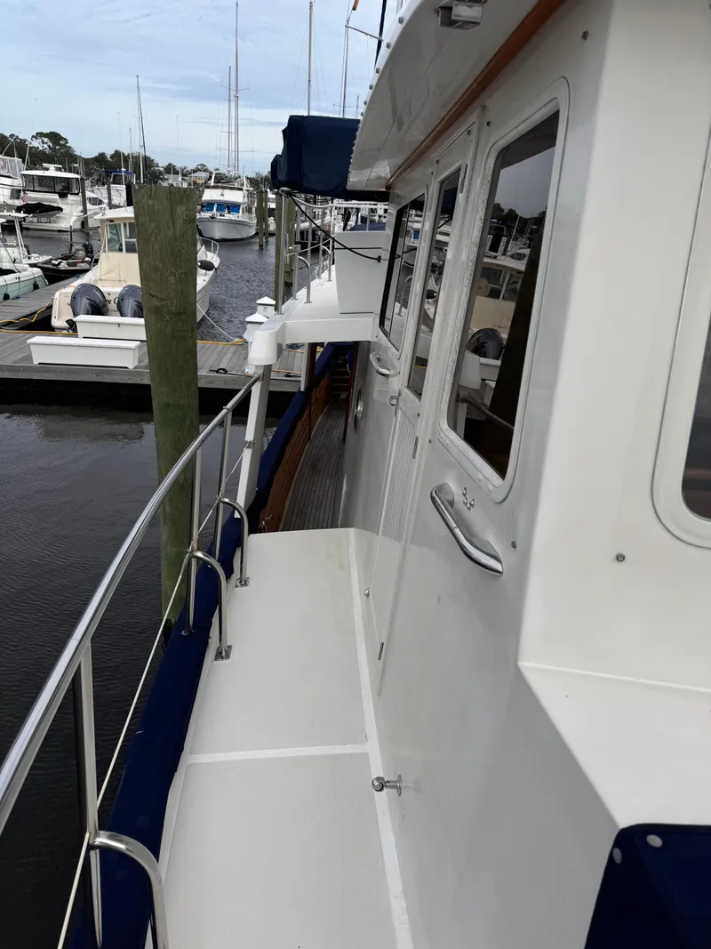 Slide: The Image of Kadey-Krogen 48 yacht, 1996 model, docked at a marina with visible walkway and railing. - 28