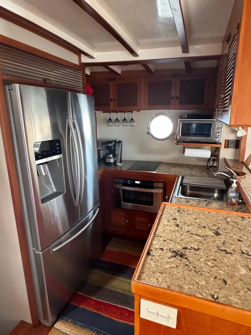 Slide: The Image of Compact kitchen in a 1996 Kadey-Krogen 48 yacht with modern appliances and wooden cabinetry. - 34
