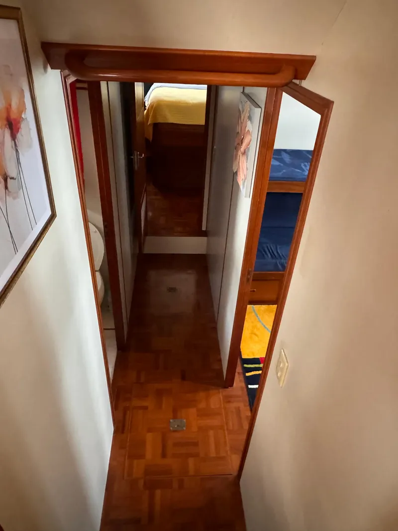 Slide: The Image of Narrow hallway inside 1996 Kadey-Krogen 48 yacht with wooden flooring and cabin doors. - 47