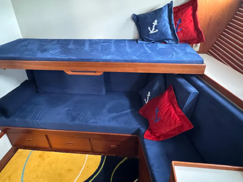 Slide: The Image of Cozy cabin interior of 1996 Kadey-Krogen 48 with blue and red nautical-themed cushions. - 49