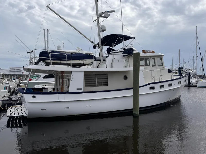Slide: The Image of Kadey-Krogen 48 yacht, 1996 model, docked at a marina under cloudy skies. - 9