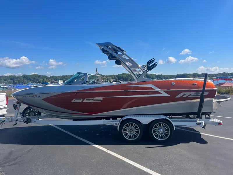 The Image of 2015 MB B52 23 boat on trailer, parked outdoors under clear blue sky. - 1