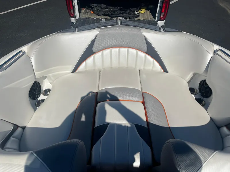 Slide: The Image of 2015 MB B52 23 boat interior with white and gray seating, orange accents. - 10