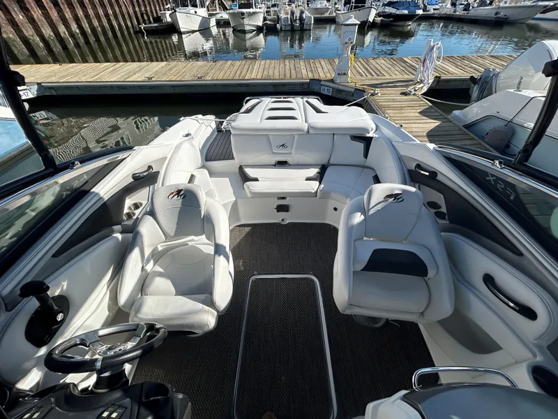Slide: The Image of 2015 Monterey 244 FSX boat interior with white seating at marina. - 10