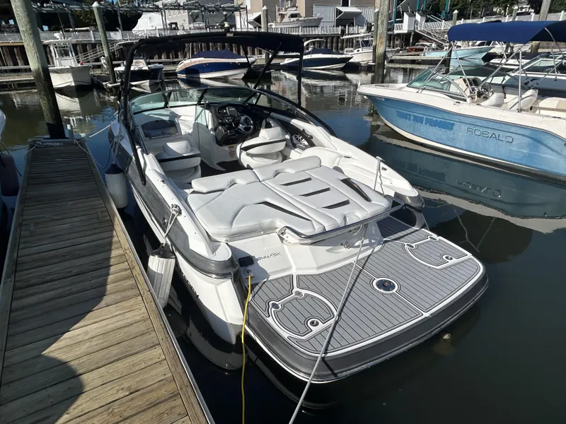 Slide: The Image of 2015 Monterey 244 FSX boat docked in marina, featuring sleek design and spacious seating. - 3