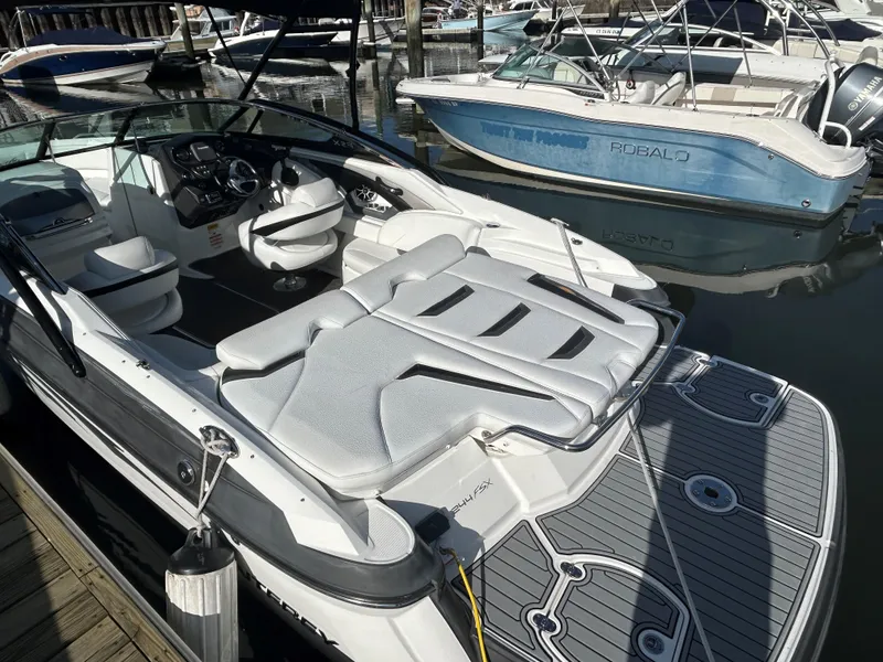 Slide: The Image of 2015 Monterey 244 FSX boat docked, featuring sleek interior and spacious seating. - 4