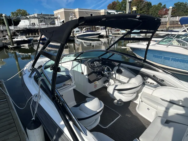 Slide: The Image of 2015 Monterey 244 FSX boat with black canopy docked at marina. - 5