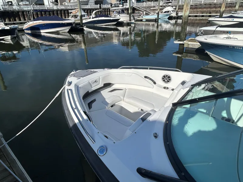 Slide: The Image of 2015 Monterey 244 FSX boat docked in a marina, featuring spacious seating and sleek design. - 6