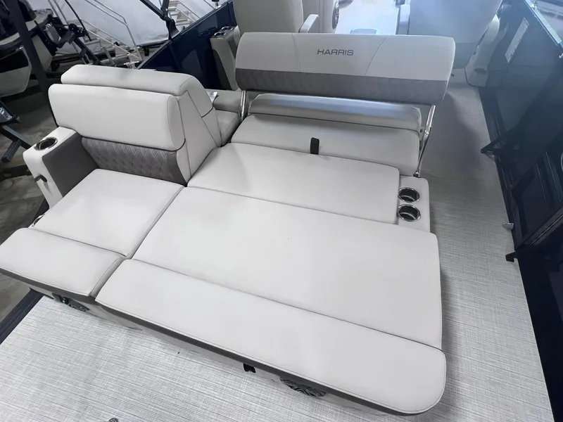 Slide: The Image of 2024 Harris Sunliner 230 boat interior with luxurious white seating and cup holders. - 11