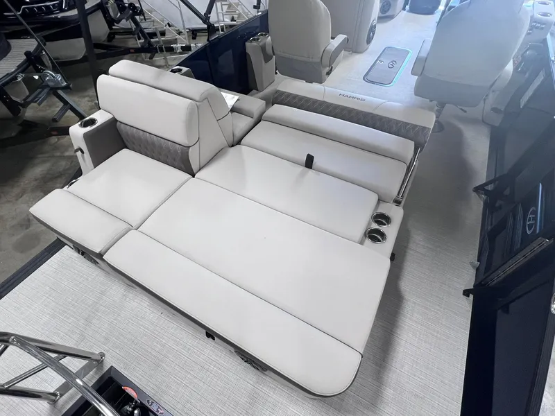Slide: The Image of 2024 Harris Sunliner 230 boat interior with convertible seating and cup holders. - 12