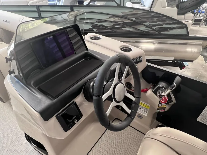 Slide: The Image of 2024 Harris Sunliner 230 boat dashboard with steering wheel and control panel. - 13