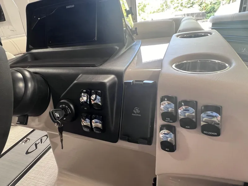 Slide: The Image of 2024 Harris Sunliner 230 dashboard with controls and cup holders. - 14