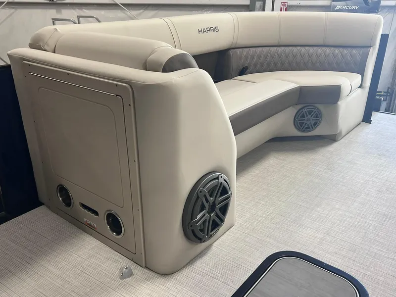 Slide: The Image of 2024 Harris Sunliner 230 boat interior with beige seating and built-in speakers. - 16