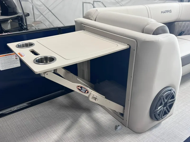 Slide: The Image of 2024 Harris Sunliner 230 boat interior with foldable table and cup holders. - 17