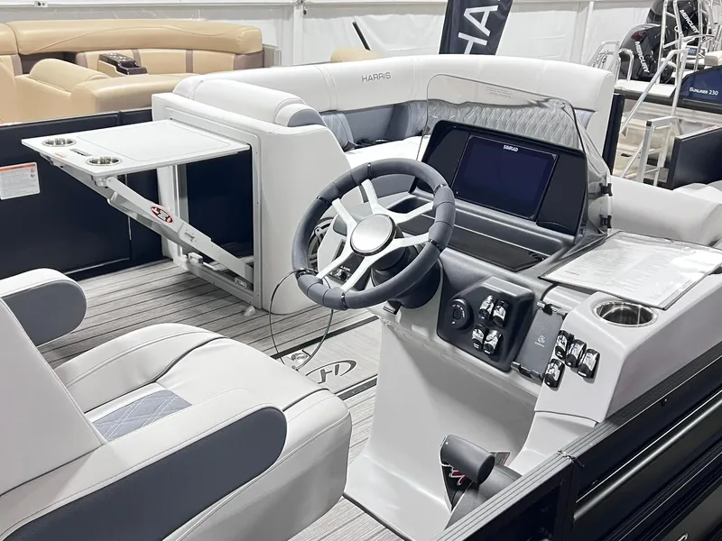 Slide: The Image of 2024 Harris Sunliner 230 boat interior with modern steering console and seating. - 18