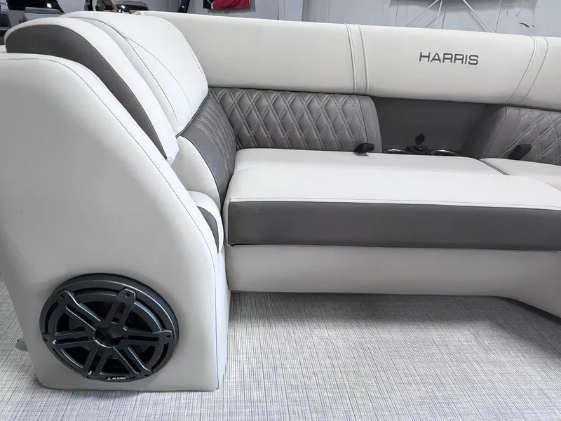 Slide: The Image of 2024 Harris Sunliner 230 boat interior with plush seating and built-in speaker. - 20