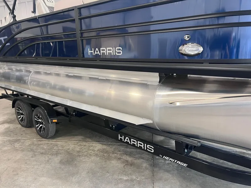 Slide: The Image of 2024 Harris Sunliner 230 pontoon boat on trailer in showroom. - 22