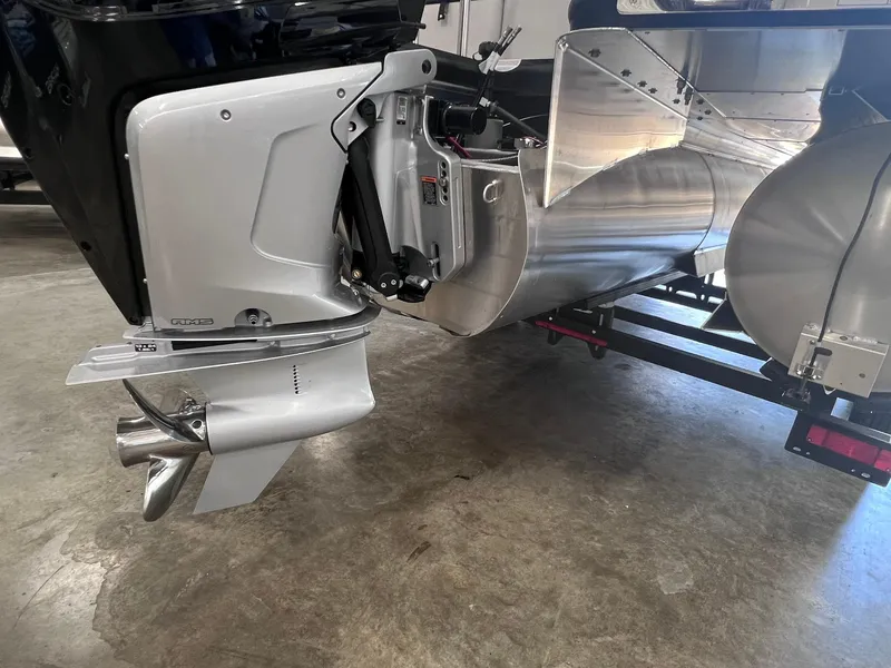 Slide: The Image of 2024 Harris Sunliner 230 boat engine and propeller detail in a garage setting. - 25