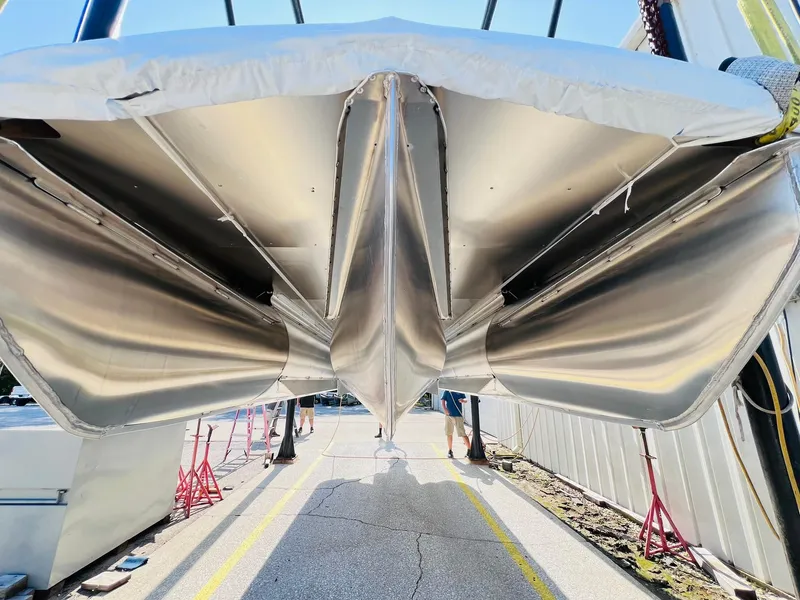 Slide: The Image of 2024 Harris Sunliner 230 pontoon boat undercarriage view in a storage facility. - 30