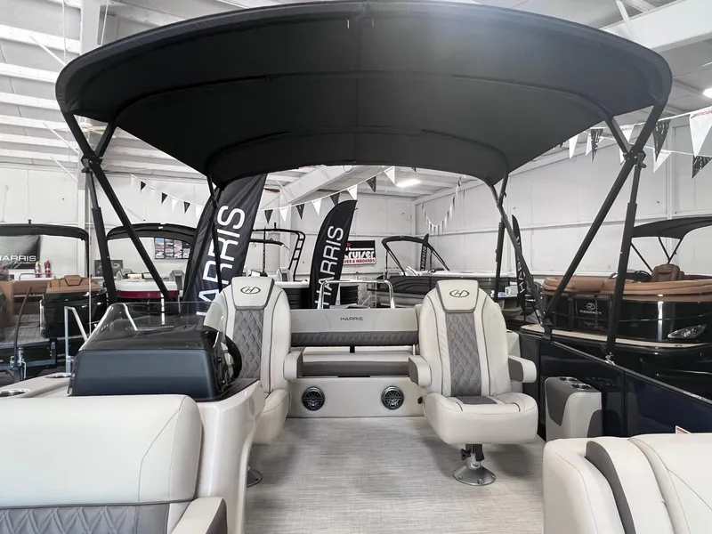 Slide: The Image of 2024 Harris Sunliner 230 pontoon boat interior with plush seating and canopy. - 9