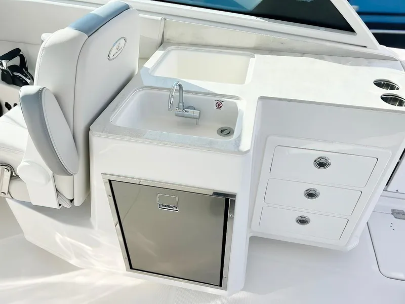 Slide: The Image of 2025 Sailfish 316 DC boat interior with sink, storage drawers, and seating. - 12