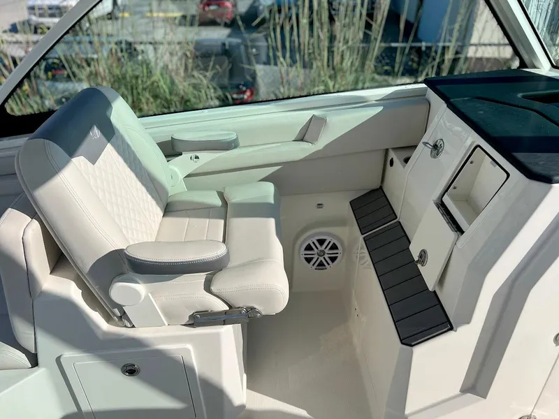 Slide: The Image of Interior of 2025 Sailfish 316 DC boat, featuring a luxurious white seat and storage compartments. - 13