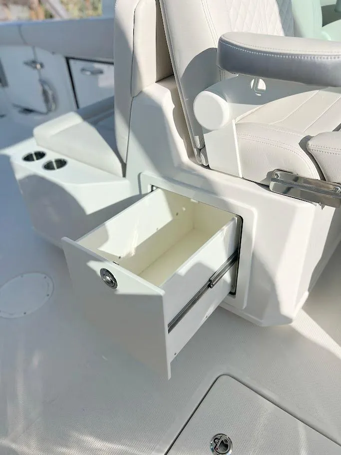 Slide: The Image of 2025 Sailfish 316 DC boat interior with open storage drawer and seating. - 16