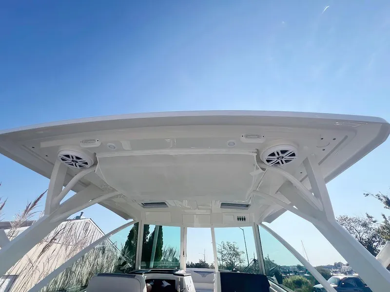 Slide: The Image of 2025 Sailfish 316 DC boat canopy with speakers under clear blue sky. - 18