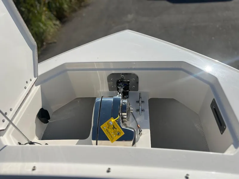 Slide: The Image of Anchor compartment of 2025 Sailfish 316 DC boat, featuring a winch and warning label. - 26