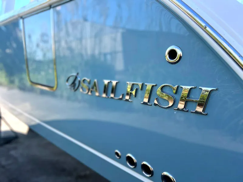 Slide: The Image of 2025 Sailfish 316 DC boat with metallic logo on blue hull. - 33