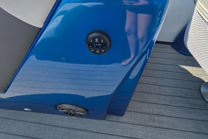 Slide: The Image of 2025 Manitou 25' LX RFXW boat interior with blue panel and speaker system. - 10