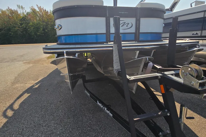 Slide: The Image of 2025 Manitou 25' LX RFXW pontoon boat on trailer, parked outdoors. - 4