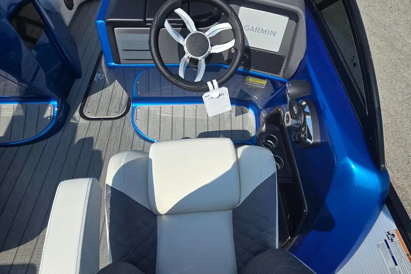 Slide: The Image of 2025 Manitou 25' LX RFXW boat cockpit with Garmin display and steering wheel. - 5