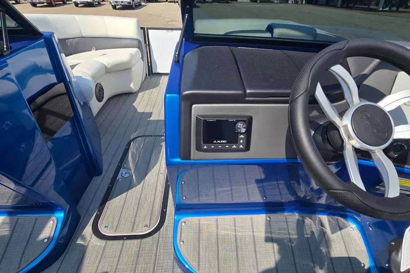 Slide: The Image of 2025 Manitou 25' LX RFXW boat interior with steering wheel and seating area. - 6