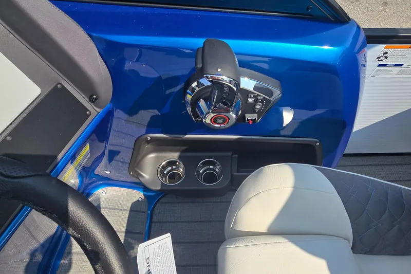 Slide: The Image of 2025 Manitou 25' LX RFXW boat interior with steering controls and cup holders. - 7