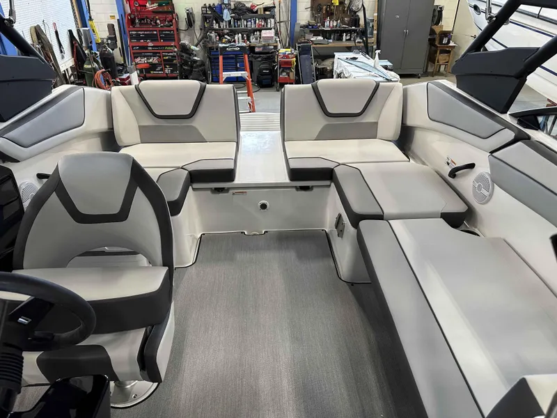 Slide: The Image of 2025 Yamaha Boats AR220 interior with modern seating and sleek design in a workshop setting. - 5