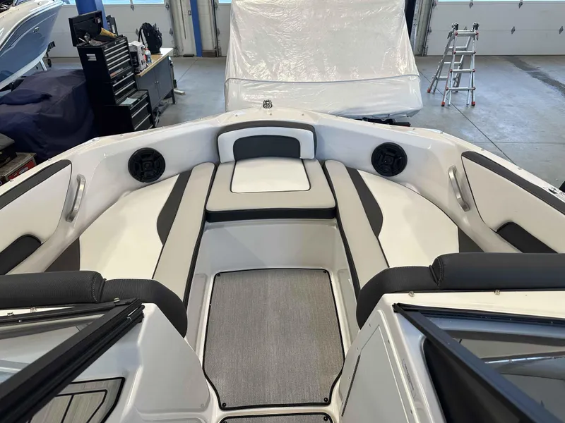 Slide: The Image of 2025 Yamaha Boats SX195 interior with sleek seating and modern design in a garage setting. - 8