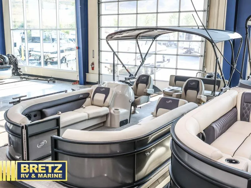 Slide: The Image of 2024 Aria Ultra-Lounge A24UC pontoon boat in showroom, featuring luxurious seating and canopy. - 4