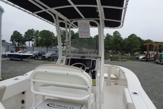 Slide: The Image of 2025 Robalo R202 Explorer boat interior with console and seating, parked outdoors. - 27