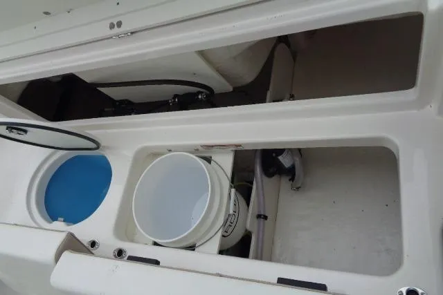 Slide: The Image of 2025 Robalo R202 Explorer boat storage compartments with bucket and blue interior. - 38