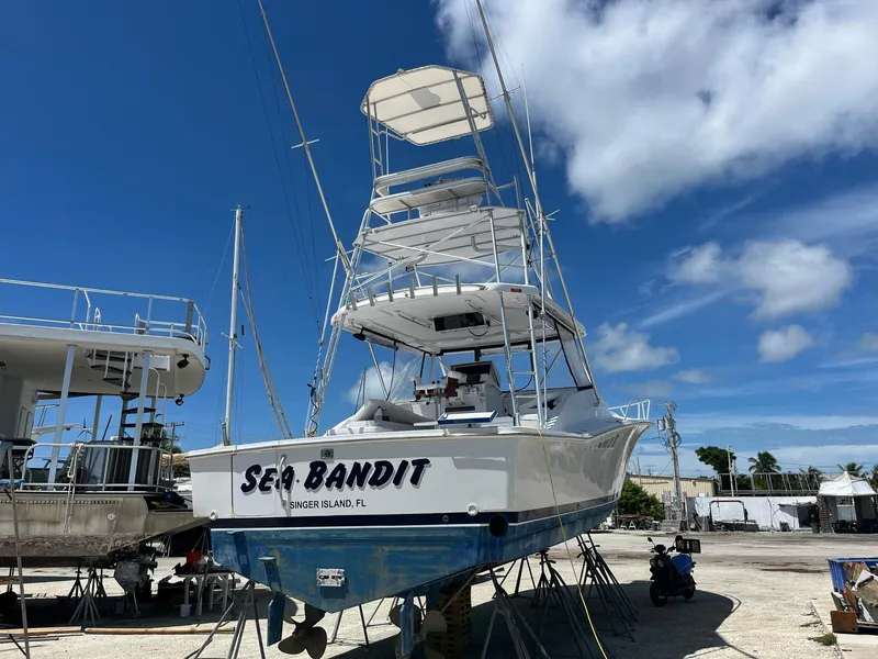 Slide: The Image of 1998 Luhrs 40 Open boat "Sea Bandit" on dry dock under clear blue sky. - 1