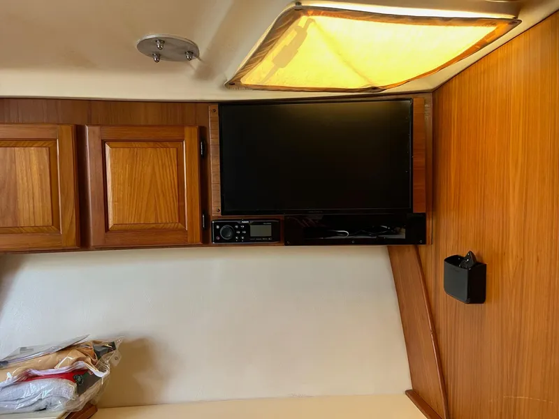 Slide: The Image of 1998 Luhrs 40 Open cabin interior with TV and wooden cabinets. - 11