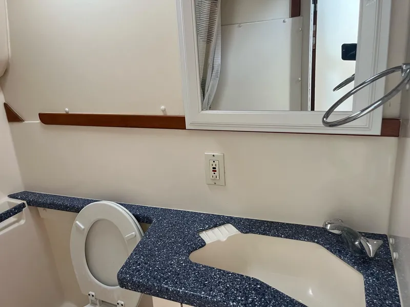 Slide: The Image of 1998 Luhrs 40 Open yacht bathroom with blue countertop and white fixtures. - 13