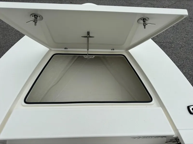 Slide: The Image of 2025 Hewes 16 Redfisher boat storage compartment open, showcasing interior space. - 8