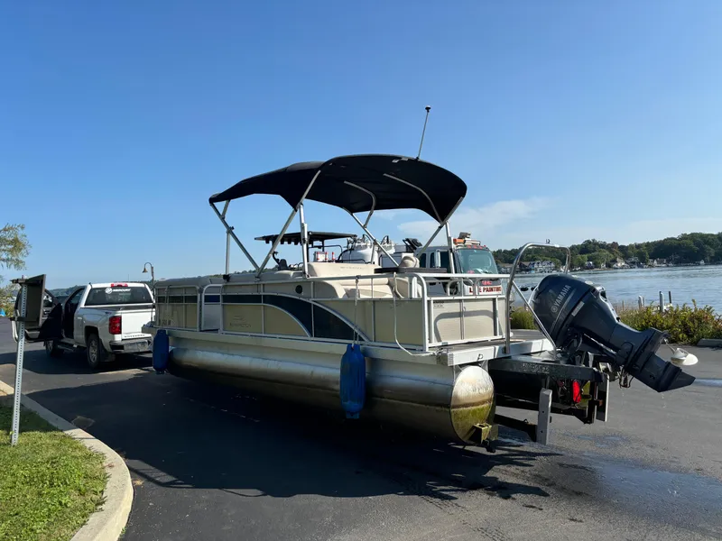 Slide: The Image of 2014 Bennington 24 SSLX pontoon boat on trailer by a lake. - 10