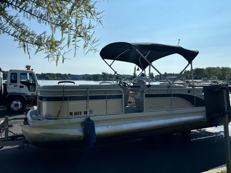 Slide: The Image of 2014 Bennington 24 SSLX pontoon boat parked near a lake. - 11